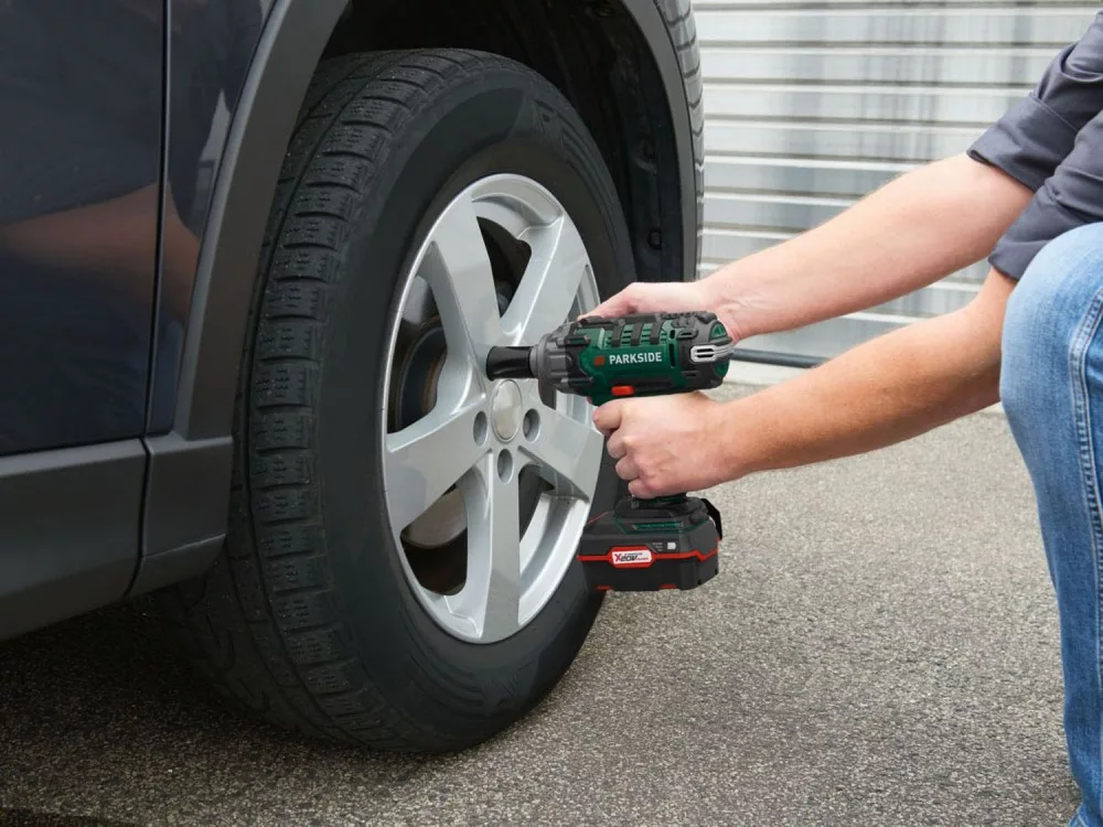 The impact wrench being used to remove a car wheel nut